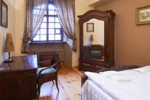 a bedroom with a bed and a dresser and a mirror at Cozy Apartment in Gothic style house in the Heart of the Old Town in Vilnius