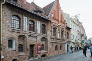 people walking down a street in an old brick building at Cozy Apartment in Gothic style house in the Heart of the Old Town in Vilnius