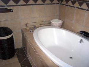 
a white bath tub sitting next to a white sink at See More Guest House in East London
