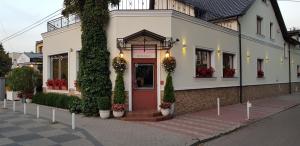 a building with a red door on a street at Pokoje De Luxe Figaro in Płock