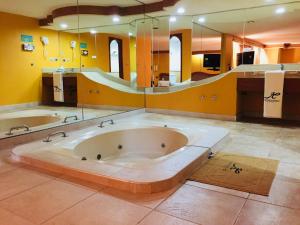 duża łazienka z dużą wanną i dużym lustrem w obiekcie Hotel California w mieście Meksyk