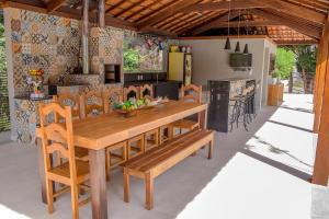 una cucina e una sala da pranzo con tavolo e sedie in legno di Pousada Recanto das Araras a Tiradentes