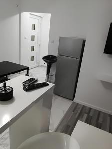 a kitchen with a refrigerator and a table and a stool at Holiday House "M" Omiš - Newly renovated house with swimming pool, 3 rooms, gym, large terrace with amazing view on town and 6 parkplaces in Omiš