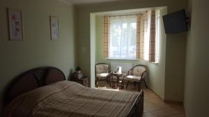 a bedroom with a bed and two chairs and a window at Posejdon in Ustronie Morskie +60 photos