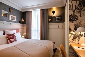 a hotel room with a bed and a desk at Royal Madeleine Hotel & Spa in Paris