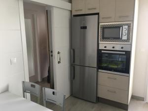 a kitchen with a stainless steel refrigerator and a microwave at Apartamento San José by CasaTuristica in Ronda