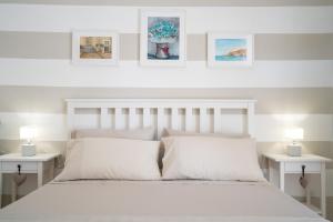 um quarto com uma cama branca e 2 mesas brancas em Mestmiché by Polignando em Polignano a Mare