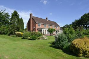 a large brick house with a green yard at The Oaks in Church Stretton