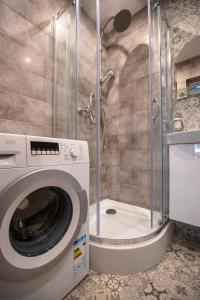 カリシュにあるJDK Apartamenty Serbinowska 53m2 6-osobowyのバスルーム(シャワー付)の洗濯機が備わります。
