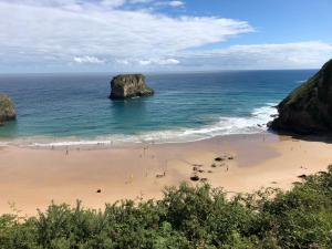 a group of people on a beach near the ocean at Apartamento Unquera - Cantabria in Unquera