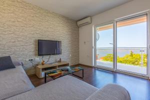 a living room with a couch and a tv at Apartmani Lucić in Crikvenica