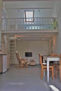 a living room with a staircase and a table and chairs at Het Huisje Breda in Breda