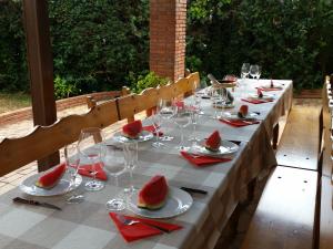 ein langer Tisch mit Weingläsern und Wassermelone darauf in der Unterkunft Villa Fabiola in Fogás de Tordera
