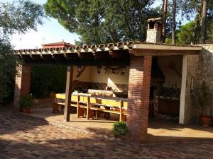 ein Pavillon mit einem Tisch und einem Dach in der Unterkunft Villa Fabiola in Fogás de Tordera