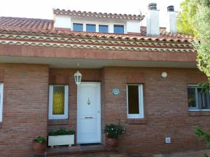 ein rotes Backsteinhaus mit einer weißen Tür in der Unterkunft Villa Fabiola in Fogás de Tordera + 40 Fotos