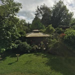 un jardín con una casa en medio de un patio en The Olive Branch at The Poplars, en Kilgetty