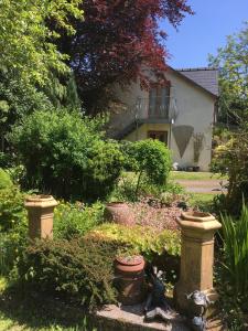 a garden with flowers and plants in front of a house at The Olive Branch at The Poplars in Kilgetty