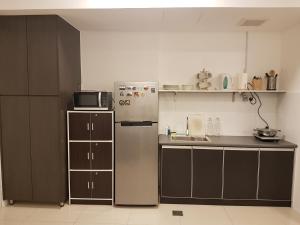 uma pequena cozinha com frigorífico e micro-ondas em SJA Suria Jelutong em Shah Alam