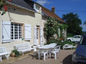 a table and chairs outside of a house with a christmas tree at La petite maison - L'Ouche Charlot in Maux