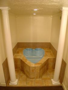 a room with a blue tub with two columns at Wildwood Inn in Florence