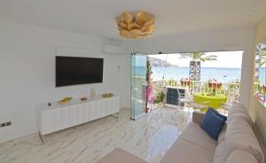 a living room with a couch and a tv and the ocean at Apartamento Daniela in Benidorm