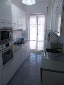 a kitchen with white cabinets and a stove top oven at La casa di Annisa in Maiori