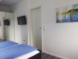 アウリッヒにあるAuszeit & Ankerplatzのベッドルーム1室(ベッド1台、壁掛けテレビ付)