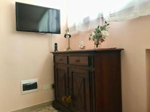 a flat screen tv on a wall with a wooden cabinet at Casa Foscolo in Ferrara