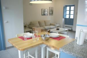 a kitchen and living room with a table and a couch at Las Casinas de la Granda in Nueva de Llanes