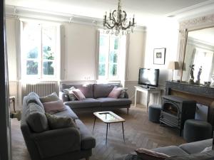 uma sala de estar com dois sofás e uma lareira em Manoir de Puyval em Rully