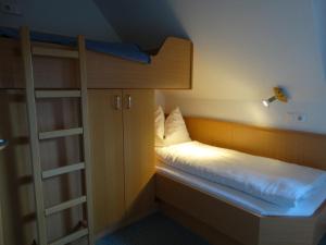 ein kleines Zimmer mit einem Etagenbett und einer Leiter in der Unterkunft Glautschhof in Weissensee