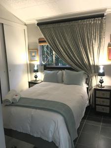 een slaapkamer met een groot wit bed en een baldakijn bij 7 Badger Street in Johannesburg