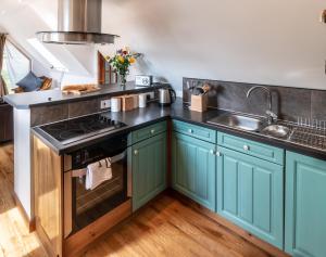a kitchen with blue cabinets and a sink at The Boathouse in Stonehaven