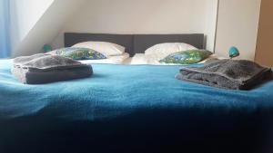 a bed with blue sheets and pillows on it at SuperiQ Villa Sopot in Sopot