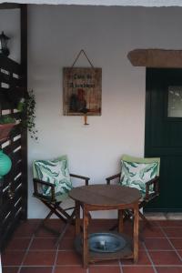 une table en bois, deux chaises, une table et une porte dans l'établissement Casa do Alambique, à Tomar