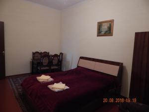 ein Schlafzimmer mit einem roten Bett mit Handtüchern darauf in der Unterkunft Zukas Hause in Achalziche