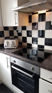 a kitchen with a black and white checkered wall at 39 Cowley Road in Liverpool