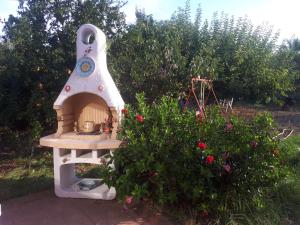 ein kleines Spielhaus in einem Garten neben einem Busch in der Unterkunft Villa dei giardini in San Leone