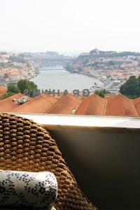 a chair sitting in front of a window with a view at Historical Porto/Gaia Apartment in Porto