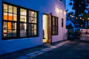 uma porta aberta para uma casa branca à noite em Renovated Historic Coconut Grove Cottage Home em Miami