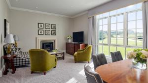 a living room with a table and chairs at Fairmont St Andrews, Scotland in St. Andrews