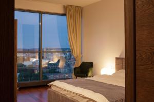 a hotel room with a bed and a large window at Luxury Panoramic Vilnius apartment in Vilnius