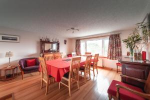 a dining room with a red table and chairs at Lathamor in Stornoway