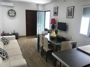 ein Wohnzimmer mit Tisch und Couch in der Unterkunft Casa Macetero en Granada in Granada