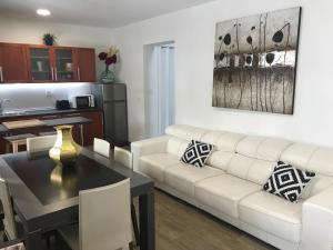 ein Wohnzimmer mit einer weißen Couch und einem Tisch in der Unterkunft Casa Macetero en Granada in Granada