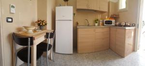 una cucina con frigorifero bianco e tavolo di Mareide a Torre Lapillo