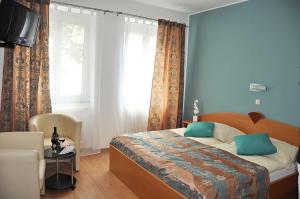 um quarto com uma cama com paredes azuis e uma janela em Kirchenwirt Heinrich Gasthof em Deutschkreutz