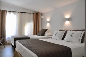 a hotel room with two beds and a window at Patios del Orfebre in Córdoba