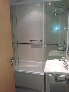 een douche met een glazen deur naast een wastafel bij Apart San Diego Recoleta in Buenos Aires +58 foto's