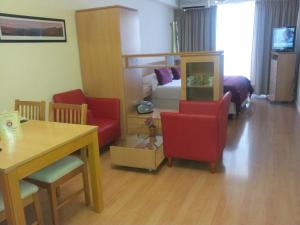 a living room with red chairs and a bed at Apart San Diego Recoleta in Buenos Aires